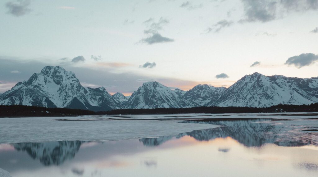 teton range reflecting off of a lake at sunset taken by grand teton national park elopement photographer