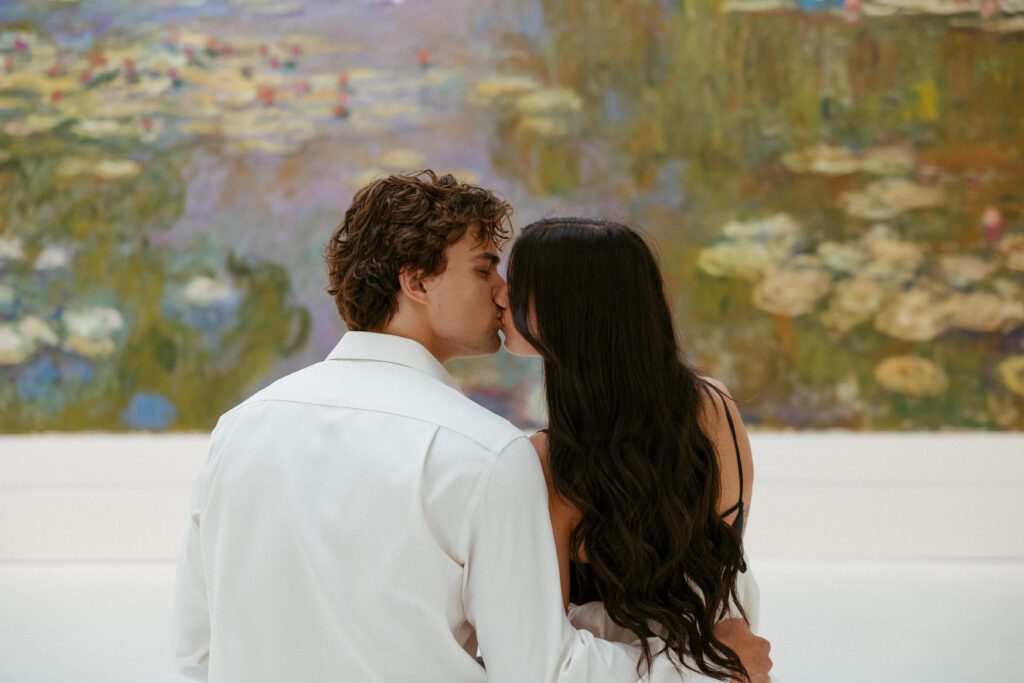 couple kissing in front of a painting at carnegie museum of art in pittsburgh taken by pittsburgh engagement photographer