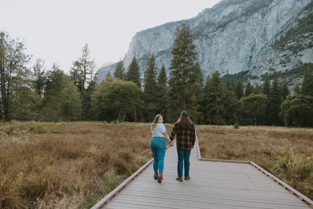 couple walking on boardwalk in yosemite valley taken by yosemite elopement photographer