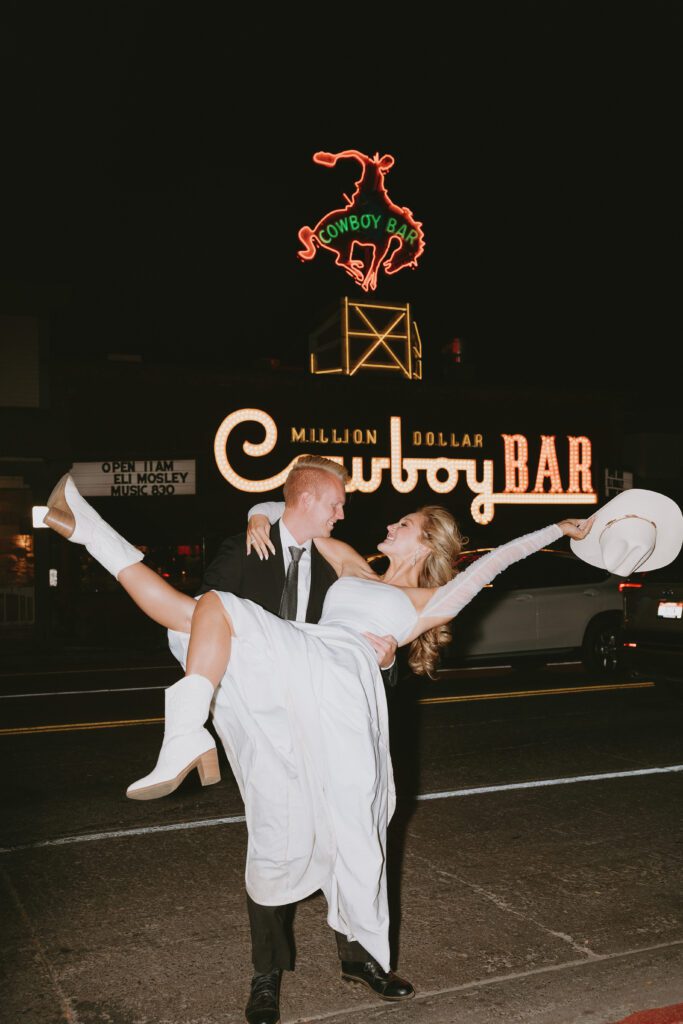 couple celebrating their elopement day in front of the million dollar cowboy bar after dark