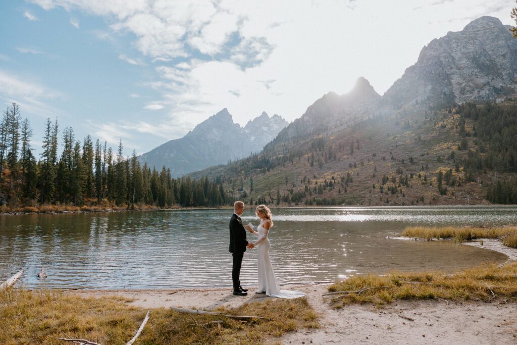 Couple exchanging vows in front of an alpine lake. Grand Teton elopement.