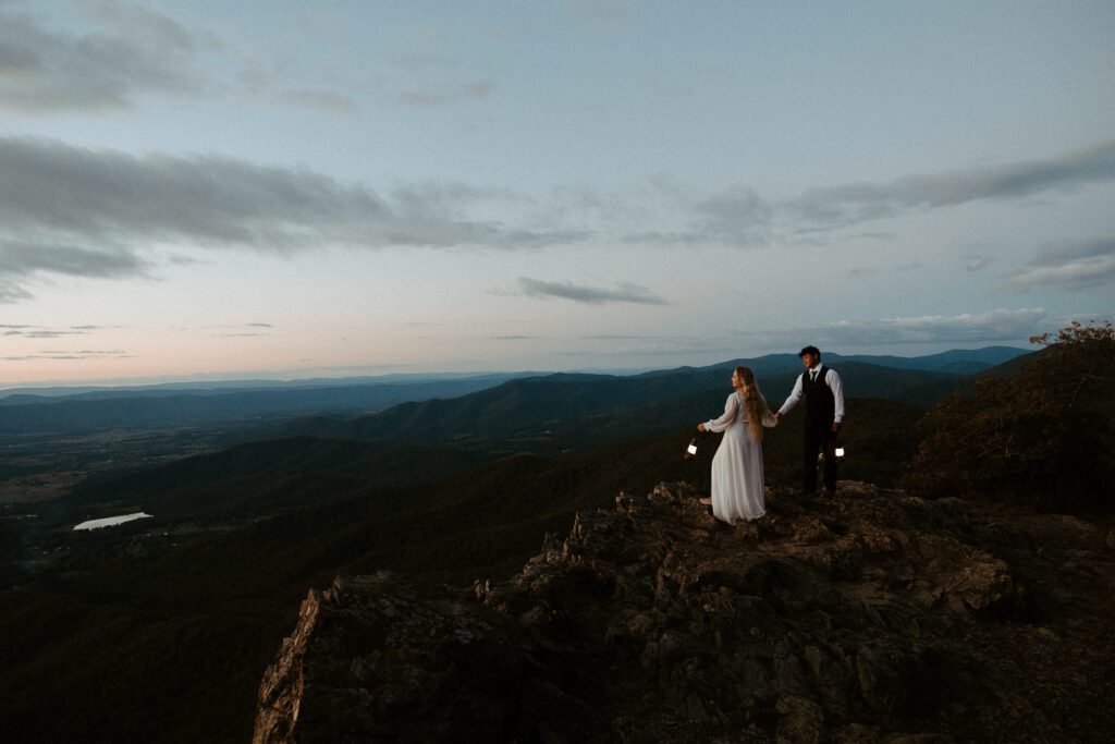 Couple holding lanterns during blue hour during a hiking elopement in Shenandoah.