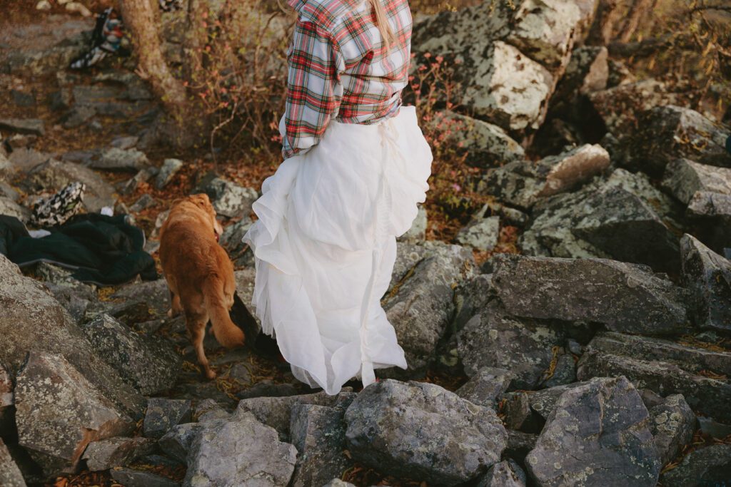 bride and her dog walking down trail in shenandoah national park at an adventure elopement