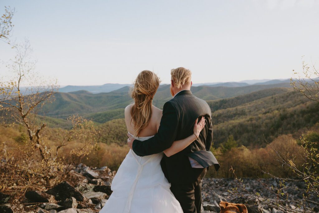 couple overlooking mountains at sunrise on their wedding day in shenandoah